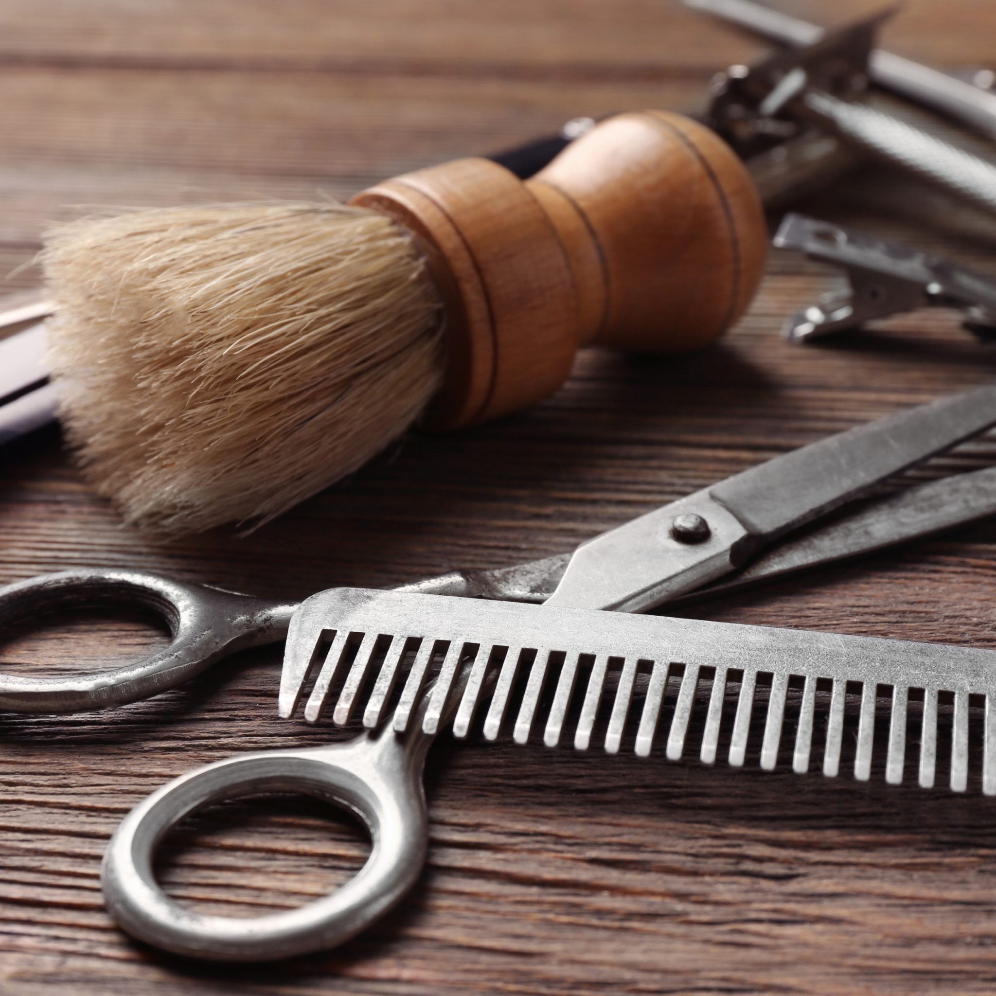 Close up of barbering equipment, shaving brush, scissors, combs